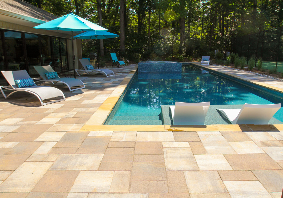 Immagine di una grande piscina monocorsia american style rettangolare nel cortile laterale con una dépendance a bordo piscina e pavimentazioni in pietra naturale