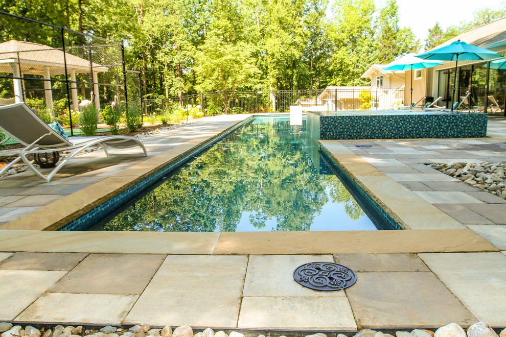 Modelo de casa de la piscina y piscina alargada de estilo americano grande rectangular en patio lateral con adoquines de piedra natural