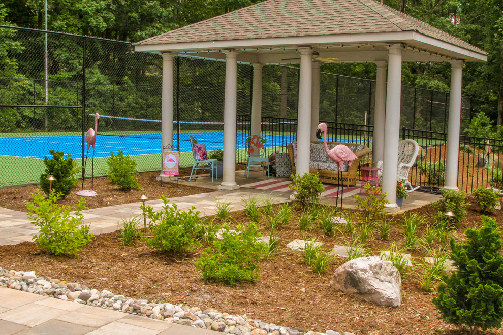 Diseño de casa de la piscina y piscina alargada de estilo americano grande rectangular en patio lateral con adoquines de piedra natural