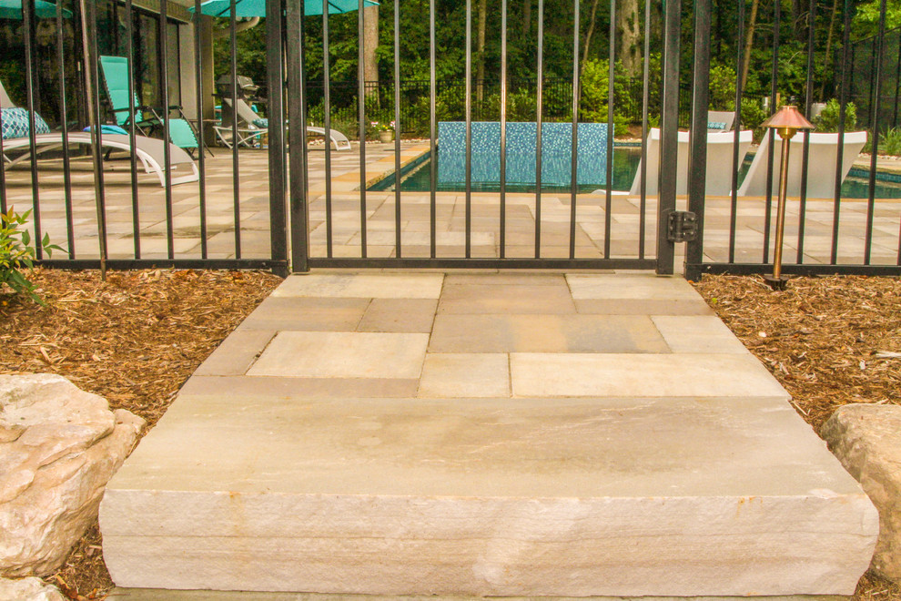 Imagen de casa de la piscina y piscina alargada de estilo americano grande rectangular en patio lateral con adoquines de piedra natural