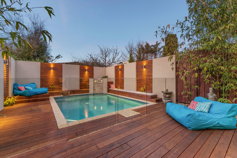 Inspiration for a mid-sized backyard rectangular pool remodel in Melbourne with decking