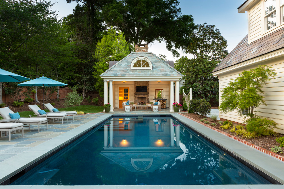 Imagen de casa de la piscina y piscina alargada clásica rectangular en patio trasero con suelo de baldosas