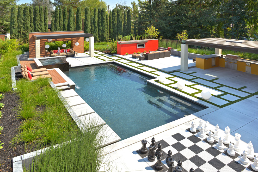 Inspiration för mycket stora moderna anpassad pooler på baksidan av huset, med marksten i betong