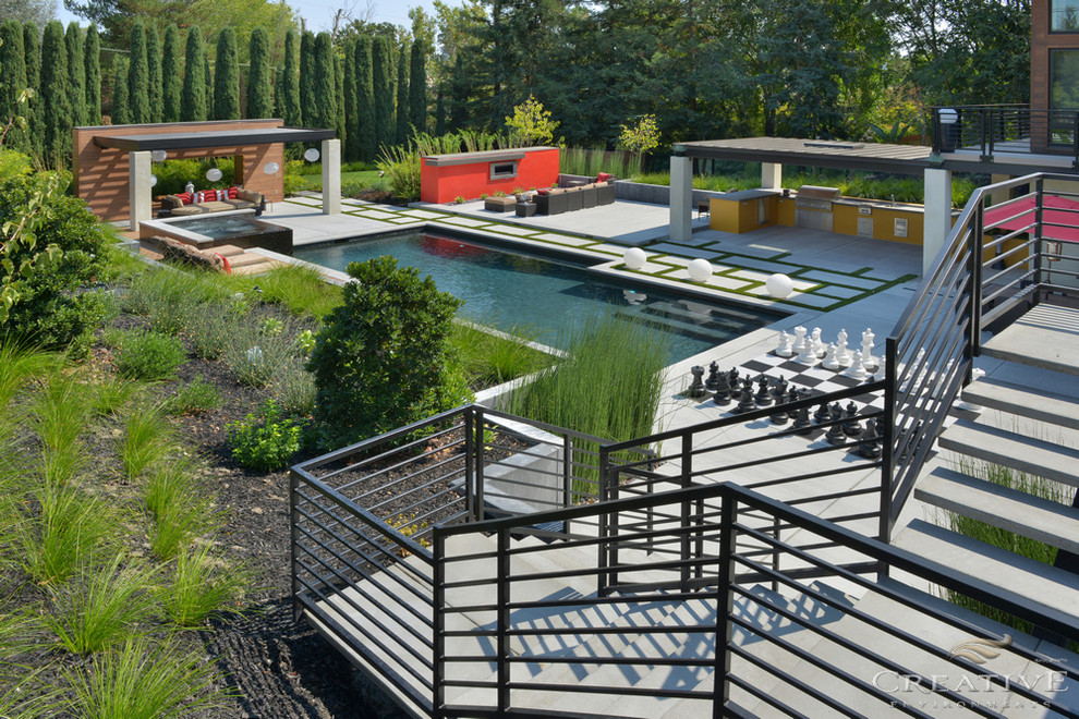 Immagine di un'ampia piscina monocorsia minimal personalizzata dietro casa con una vasca idromassaggio e pavimentazioni in cemento