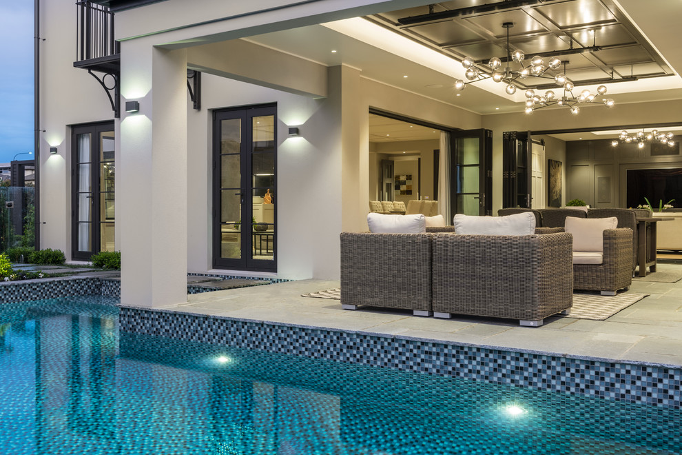 Medium sized classic side custom shaped swimming pool in Auckland with tiled flooring.