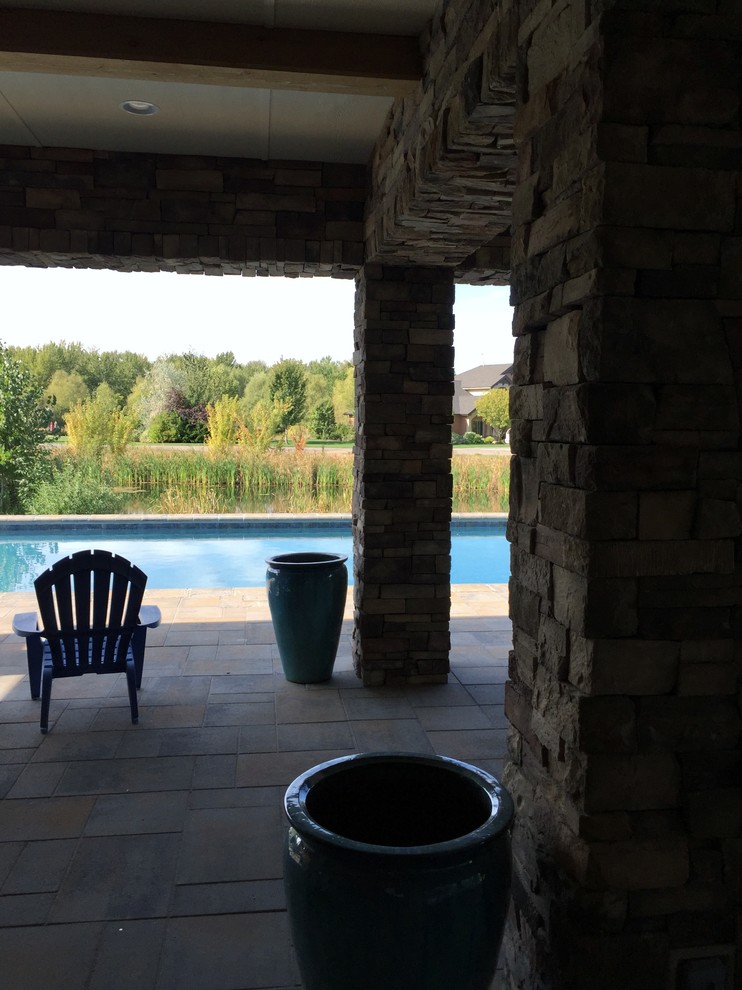 Imagen de piscina clásica grande rectangular en patio trasero con adoquines de hormigón
