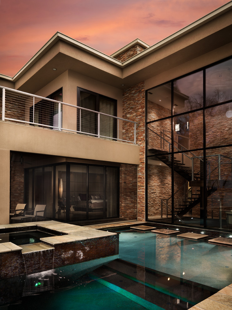 Foto di una piscina a sfioro infinito contemporanea personalizzata dietro casa con una vasca idromassaggio e piastrelle