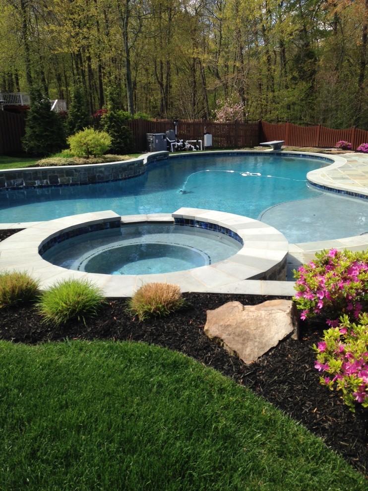 Esempio di una piscina monocorsia classica personalizzata di medie dimensioni e dietro casa con una vasca idromassaggio e piastrelle