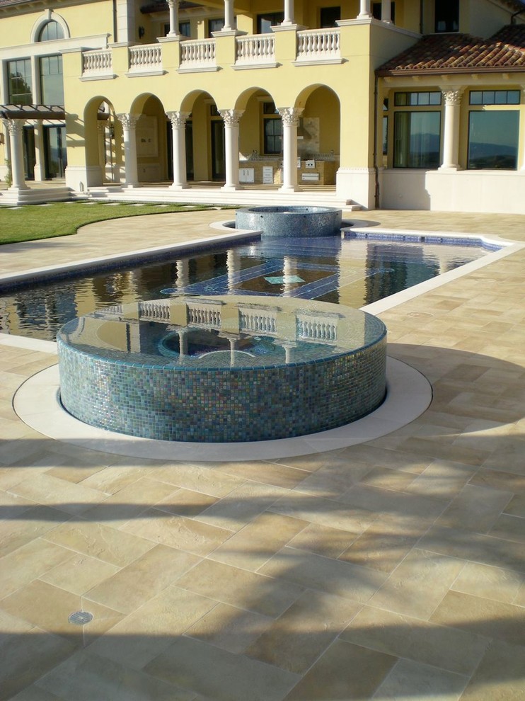 Idées déco pour une grande piscine à débordement et arrière classique sur mesure avec un bain bouillonnant et du béton estampé.