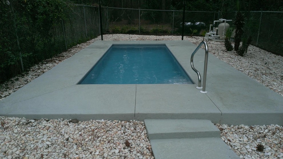 Идея дизайна: маленький прямоугольный бассейн на заднем дворе с покрытием из бетонных плит для на участке и в саду