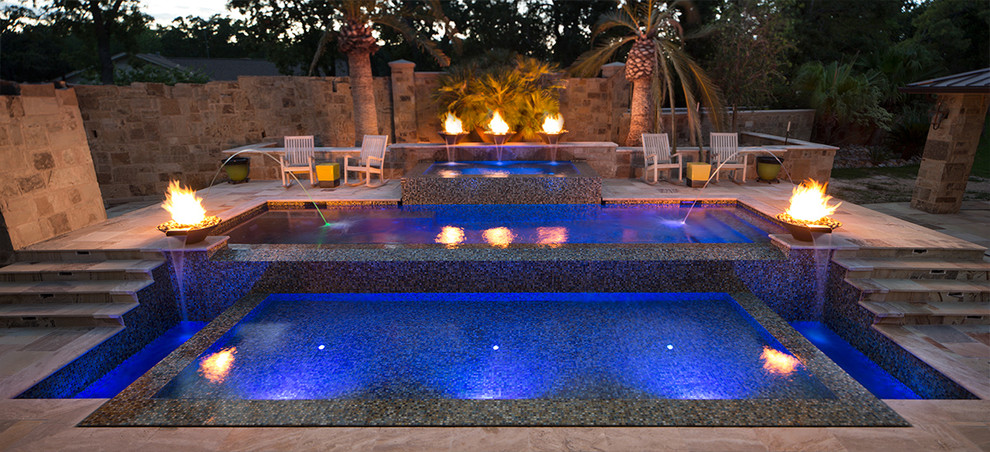 This is an example of a medium sized contemporary back rectangular infinity swimming pool in Austin.