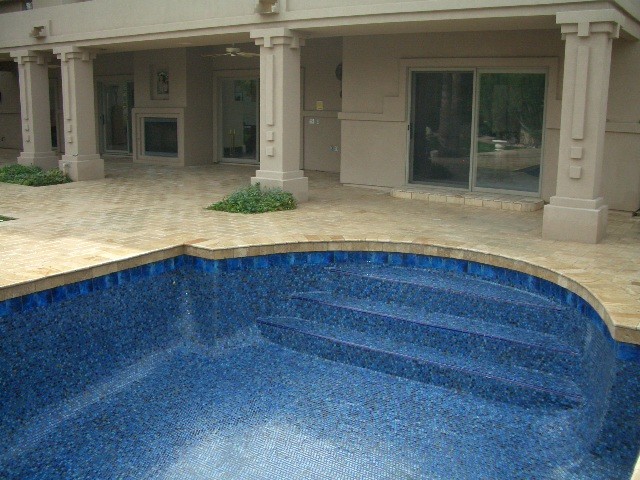 Imagen de piscina alargada mediterránea de tamaño medio rectangular en patio trasero con adoquines de ladrillo