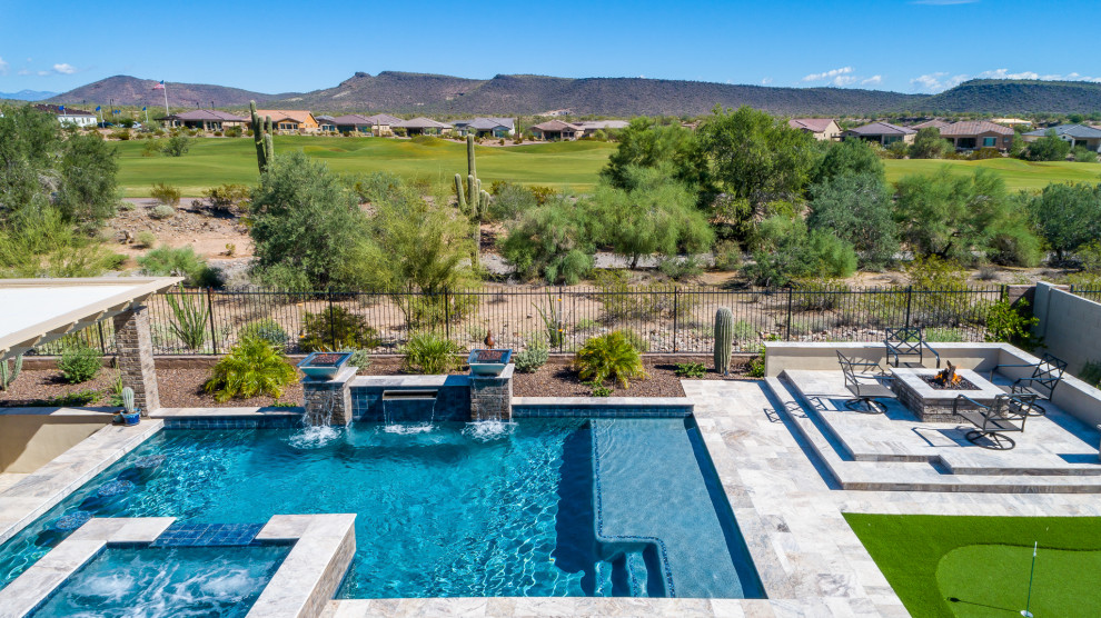 Immagine di una piscina american style rettangolare di medie dimensioni e dietro casa con una vasca idromassaggio e pavimentazioni in pietra naturale