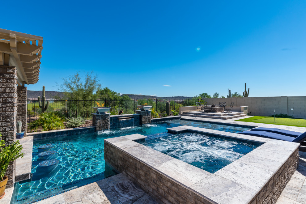 Réalisation d'une piscine arrière sud-ouest américain de taille moyenne et rectangle avec un bain bouillonnant et des pavés en pierre naturelle.