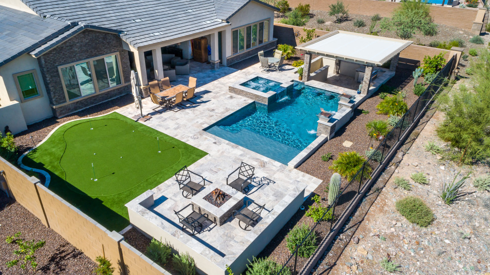 Foto de piscinas y jacuzzis de estilo americano de tamaño medio rectangulares en patio trasero con adoquines de piedra natural