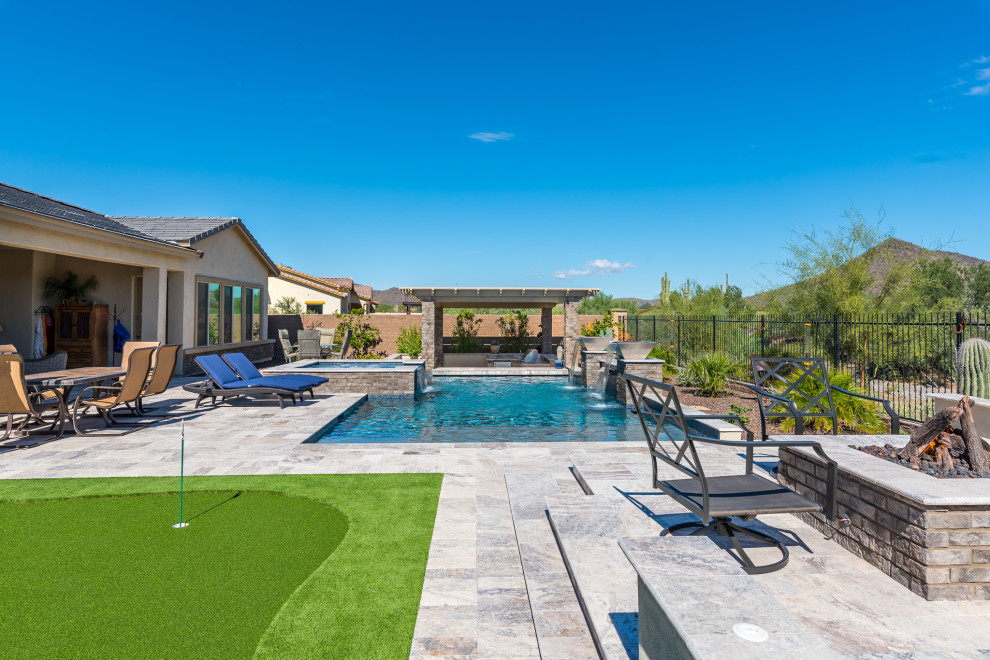 Modelo de piscinas y jacuzzis de estilo americano de tamaño medio rectangulares en patio trasero con adoquines de piedra natural
