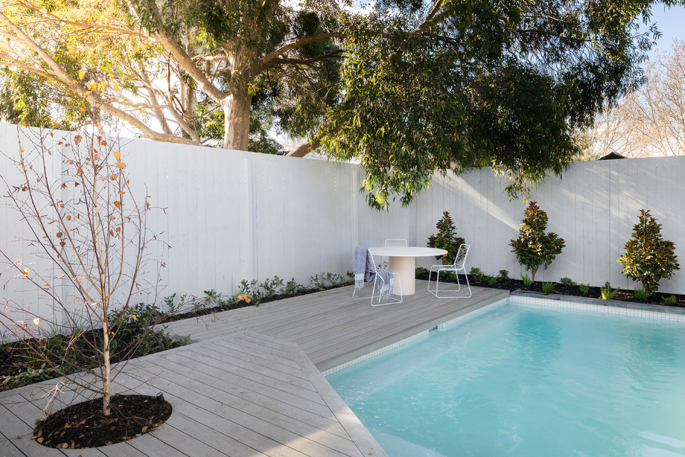 Modelo de piscina contemporánea de tamaño medio rectangular en patio trasero con entablado