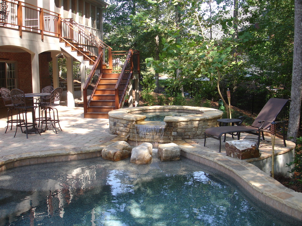 Idee per una piscina classica personalizzata di medie dimensioni e dietro casa con una vasca idromassaggio e pavimentazioni in pietra naturale
