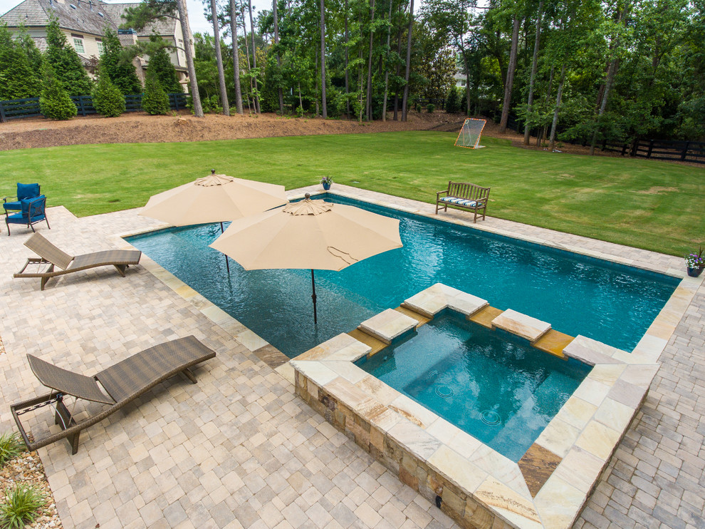 Foto di una piscina naturale stile rurale rettangolare di medie dimensioni e dietro casa con una vasca idromassaggio e pavimentazioni in pietra naturale