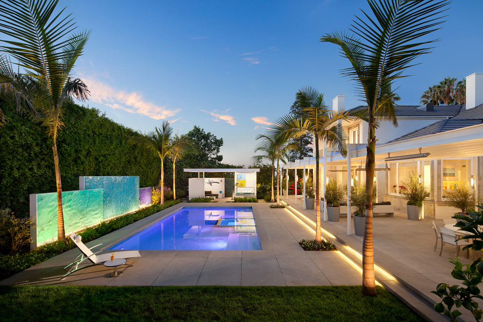 Immagine di una grande piscina monocorsia minimal rettangolare dietro casa con pavimentazioni in cemento