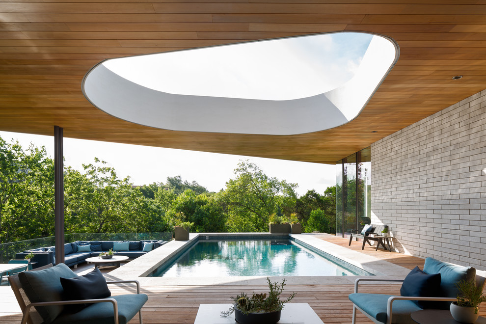 Ejemplo de piscina minimalista rectangular con entablado