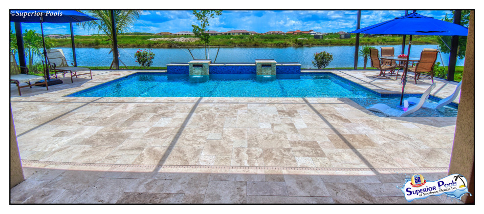 Design ideas for a medium sized contemporary back custom shaped swimming pool in Tampa with natural stone paving.