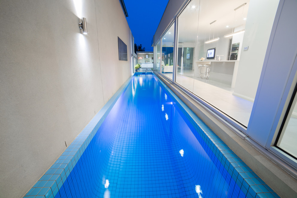 Esempio di una piscina monocorsia moderna rettangolare di medie dimensioni e nel cortile laterale con pedane