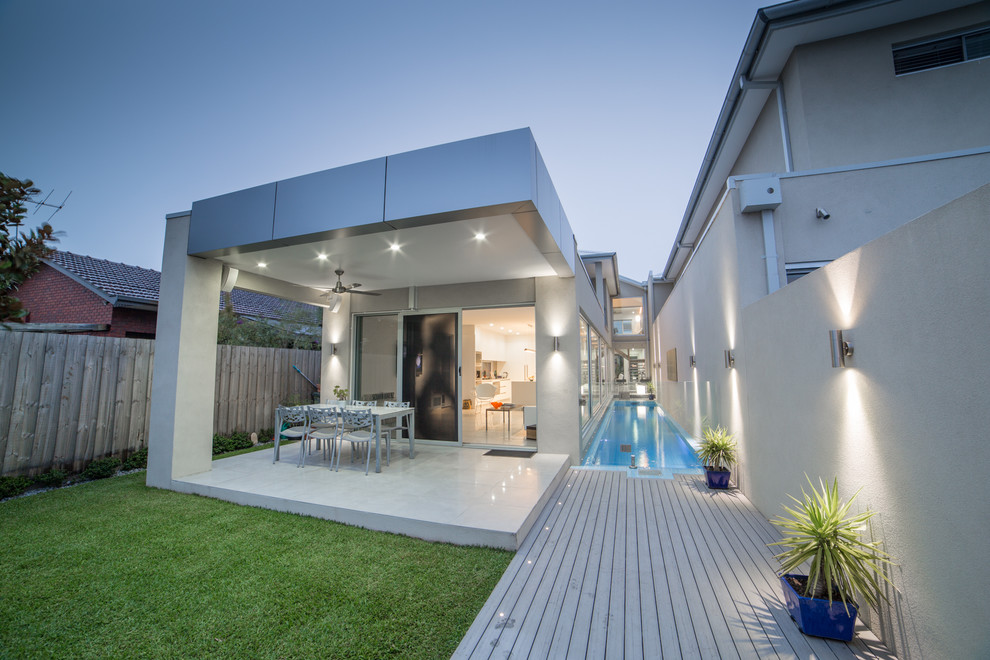 Réalisation d'un couloir de nage latéral minimaliste de taille moyenne et rectangle avec une terrasse en bois.