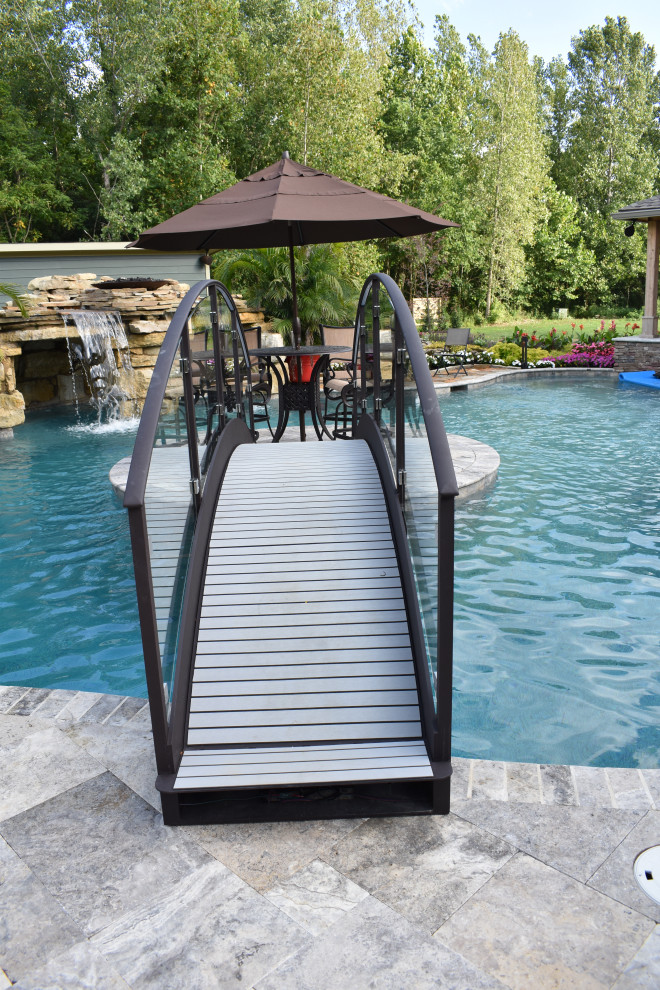 Esempio di una grande piscina naturale stile marinaro personalizzata dietro casa con una dépendance a bordo piscina e pavimentazioni in pietra naturale