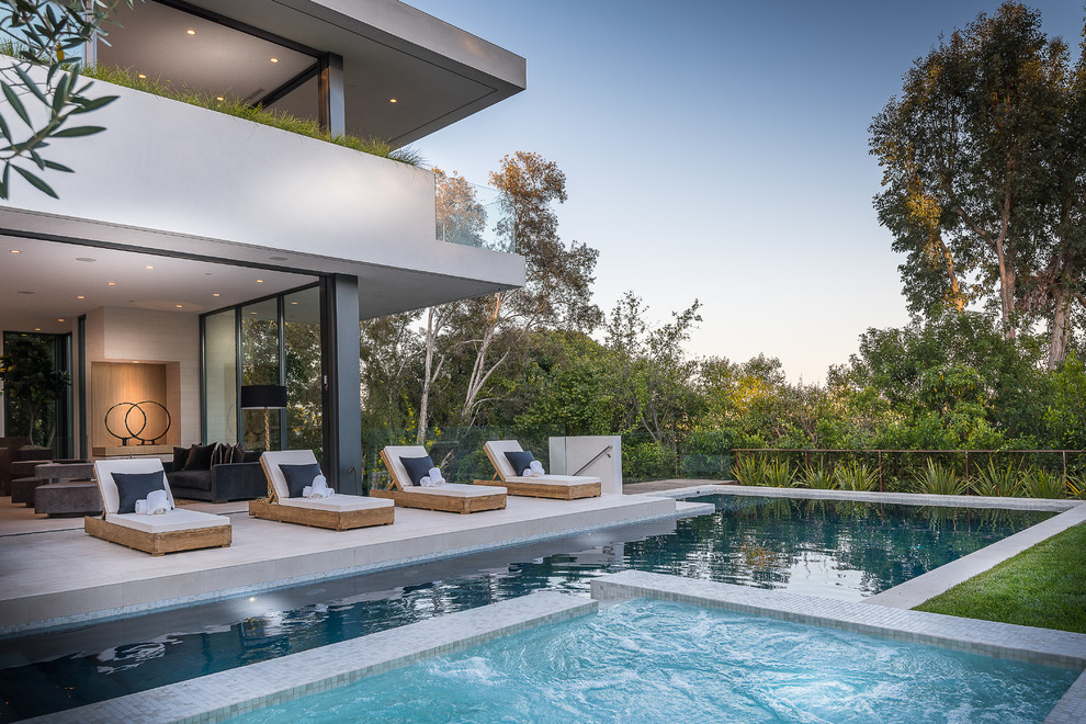 Idee per una grande piscina moderna rettangolare dietro casa con una vasca idromassaggio