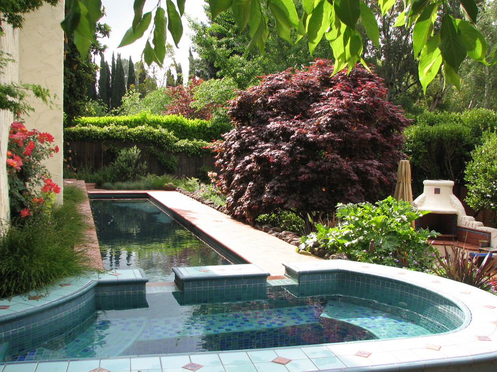 Foto de piscinas y jacuzzis alargados mediterráneos de tamaño medio rectangulares en patio lateral con adoquines de ladrillo