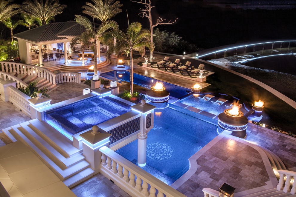 Foto de piscinas y jacuzzis infinitos mediterráneos extra grandes a medida en patio trasero con adoquines de piedra natural
