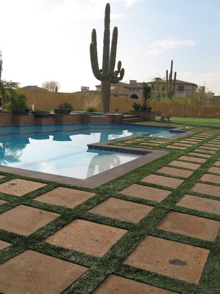 Large tuscan backyard stone and custom-shaped pool house photo in San Diego