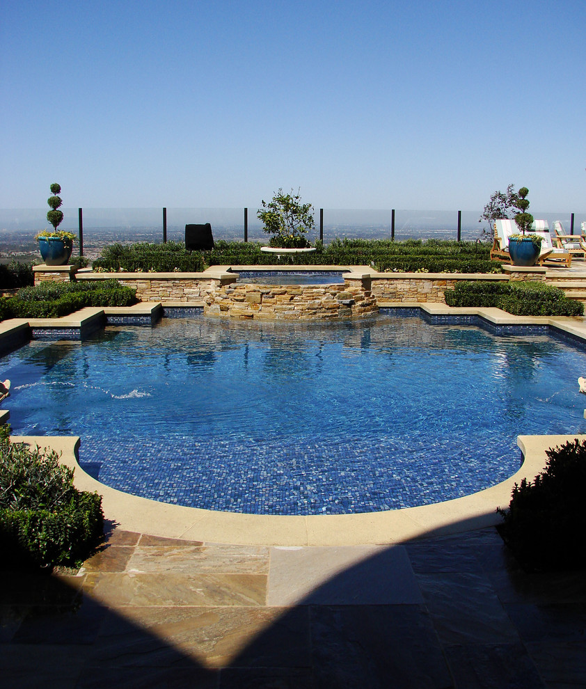 На фото: бассейн в средиземноморском стиле с забором с