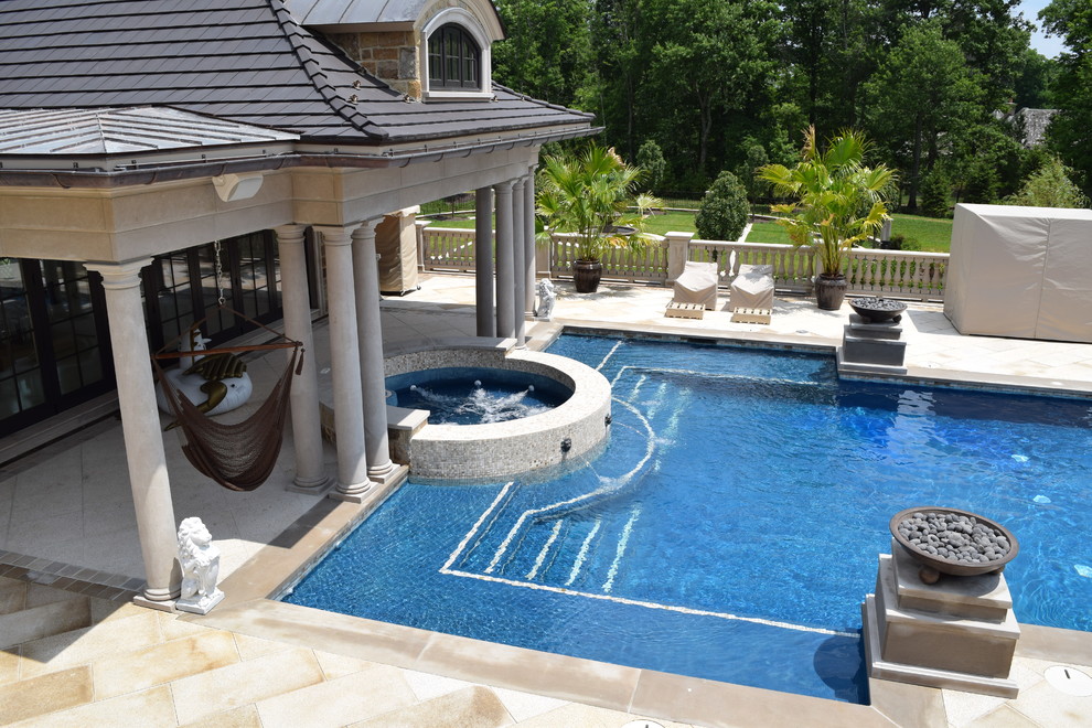 Стильный дизайн: огромный прямоугольный бассейн на заднем дворе в классическом стиле с джакузи и покрытием из каменной брусчатки - последний тренд