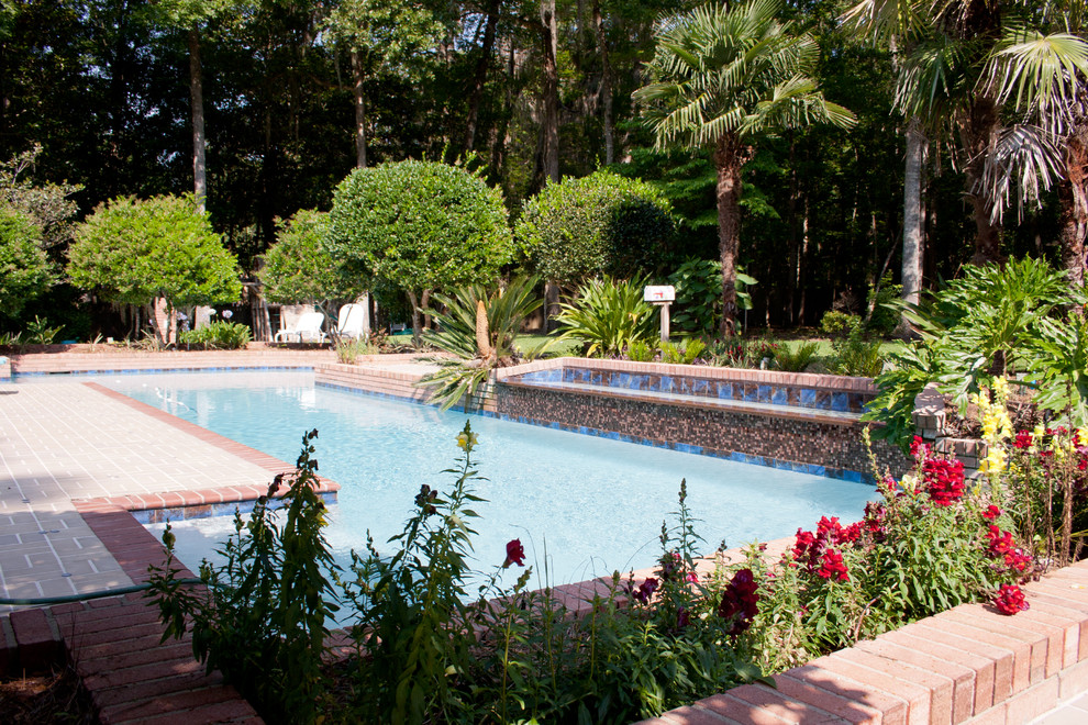 Imagen de piscina alargada ecléctica grande a medida en patio trasero con adoquines de ladrillo