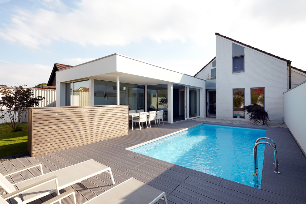 Diseño de casa de la piscina y piscina alargada contemporánea de tamaño medio rectangular en patio lateral con entablado