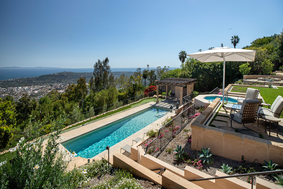 Imagen de casa de la piscina y piscina alargada mediterránea grande rectangular en patio trasero con adoquines de piedra natural