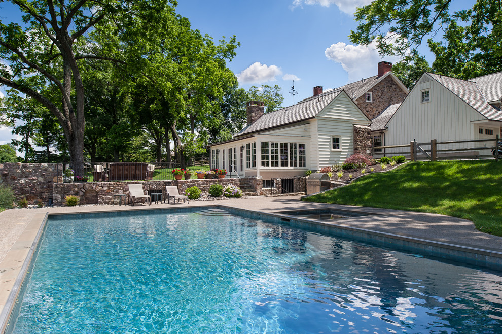 Immagine di una grande piscina classica rettangolare dietro casa con graniglia di granito