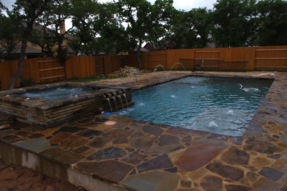 Стильный дизайн: большой естественный, прямоугольный бассейн на заднем дворе в современном стиле с покрытием из каменной брусчатки и джакузи - последний тренд