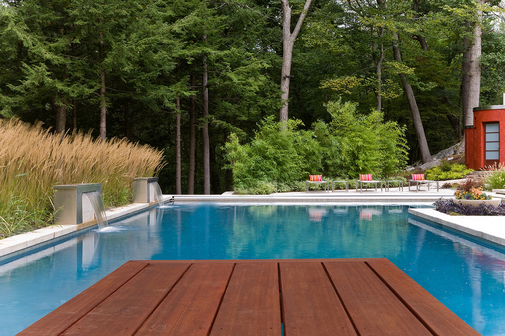 This is an example of a large contemporary back rectangular lengths hot tub in Boston with concrete slabs.