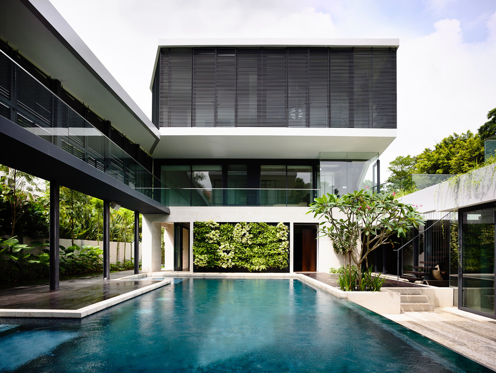 Modelo de piscina infinita contemporánea a medida en patio con entablado