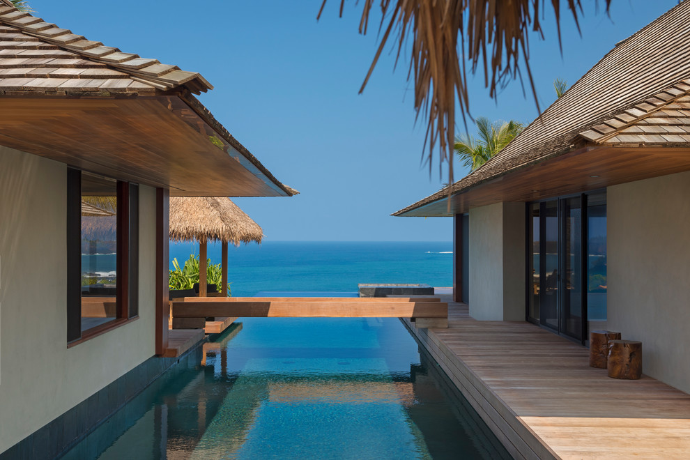 Diseño de piscinas y jacuzzis infinitos tropicales grandes rectangulares en patio con entablado