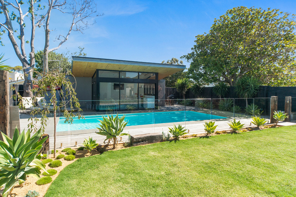 Foto di una piscina naturale design rettangolare di medie dimensioni e dietro casa con pedane