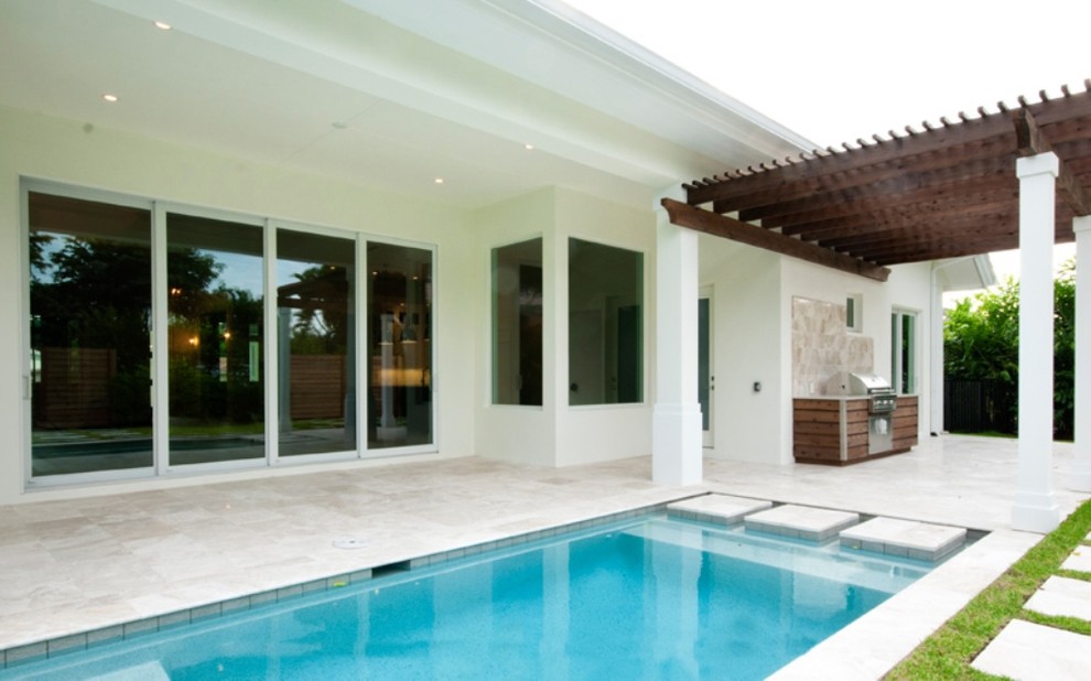 Immagine di una piscina monocorsia stile marino rettangolare di medie dimensioni e dietro casa
