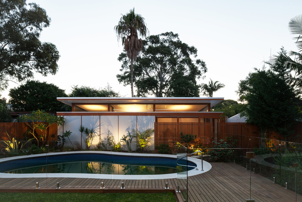 Ispirazione per una piscina moderna a "C" di medie dimensioni e dietro casa con pedane
