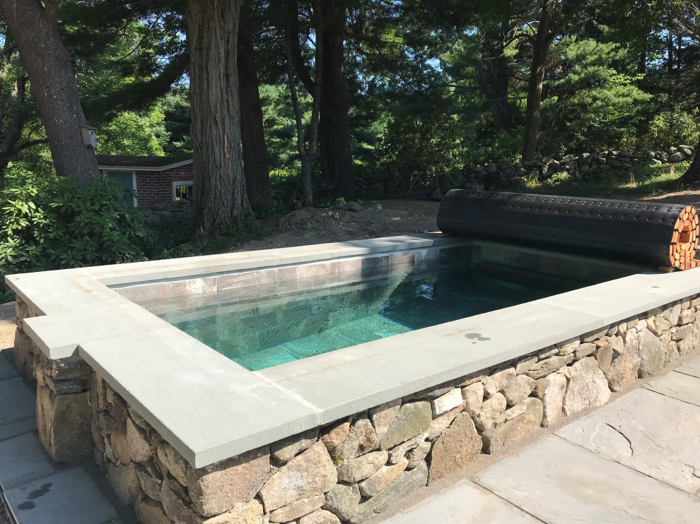 Inspiration for a small farmhouse back rectangular natural hot tub in Boston with natural stone paving.