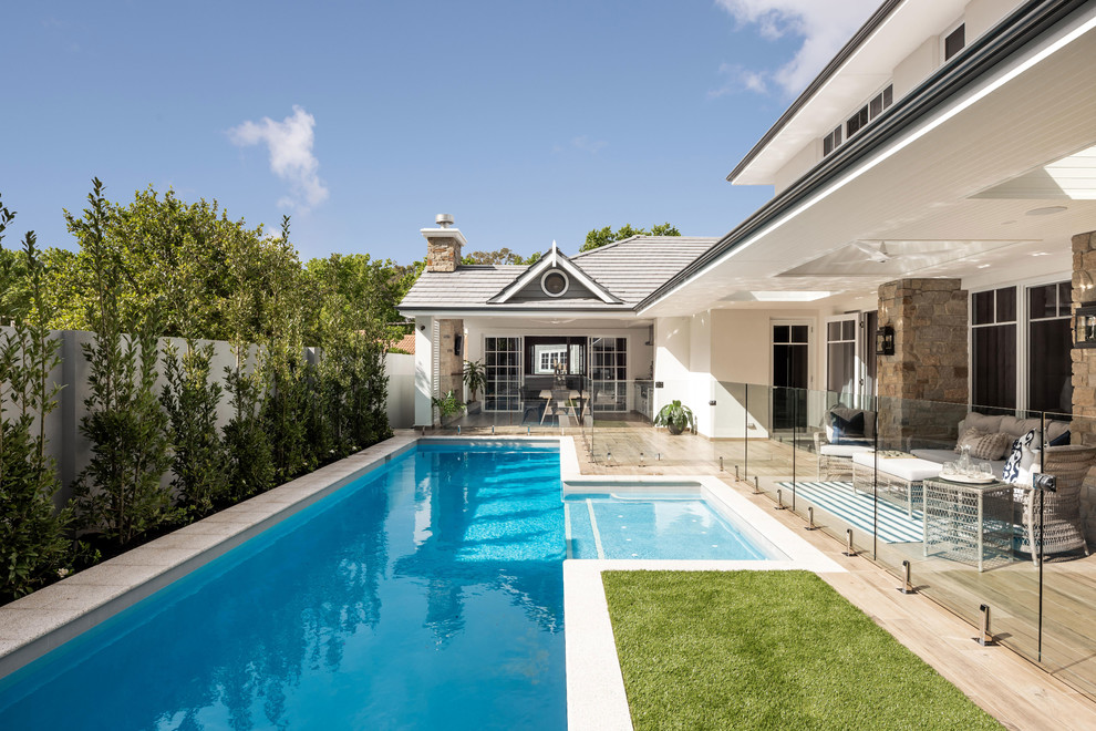 Ejemplo de piscina alargada tradicional rectangular en patio trasero con entablado