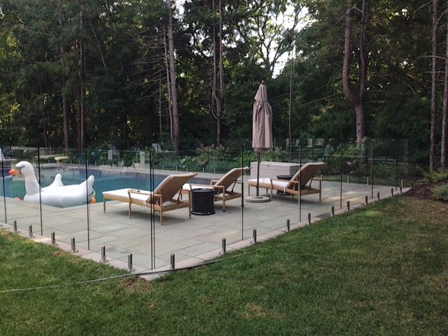 Foto di una grande piscina monocorsia minimalista rettangolare dietro casa con pavimentazioni in pietra naturale
