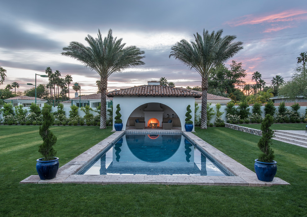 Ejemplo de casa de la piscina y piscina alargada mediterránea grande rectangular en patio trasero con adoquines de piedra natural
